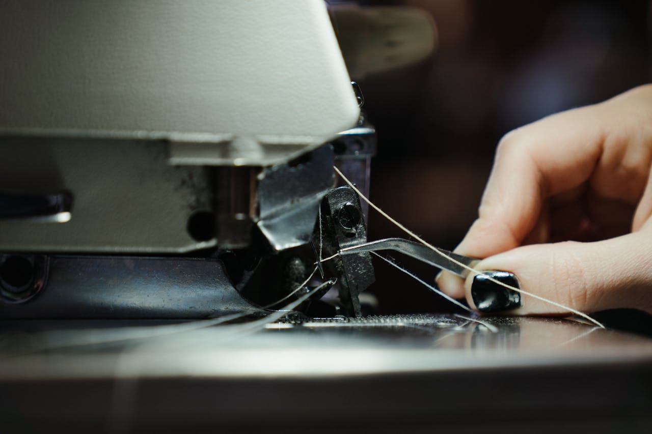 The Art of Drawing Readers In: Your attractive post title goes here Detailed close-up of a sewing machine in use, highlighting the threading process with a human hand.